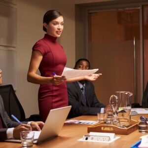 female,manager,standing,with,documents,at,business,meeting